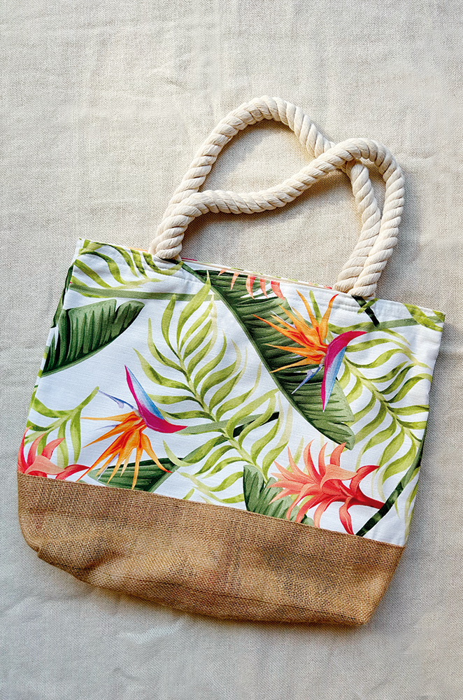 Tropical patterned beach bag with rope handles, burlap bottom on a beige background