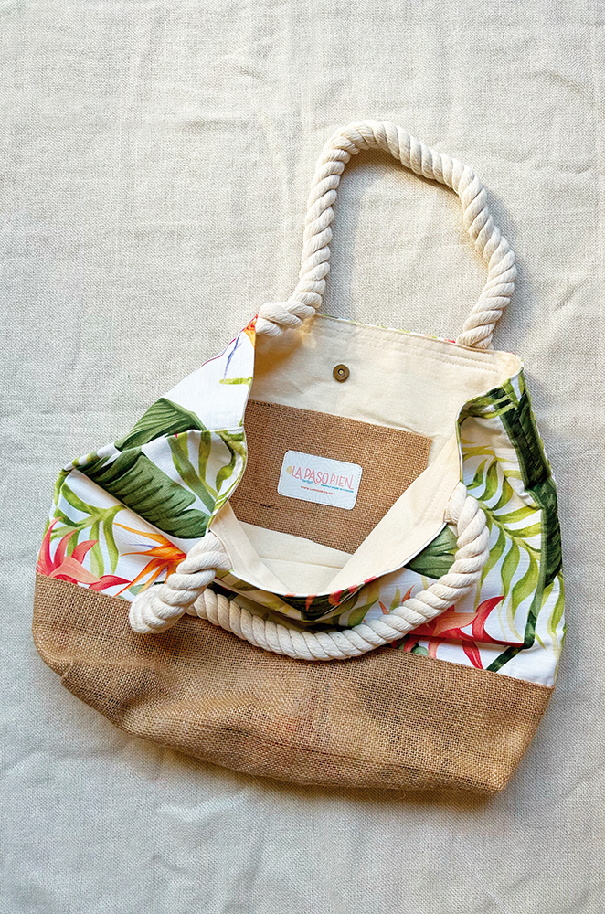 Burlap and cotton tote bag with rope handles on a light fabric background.
