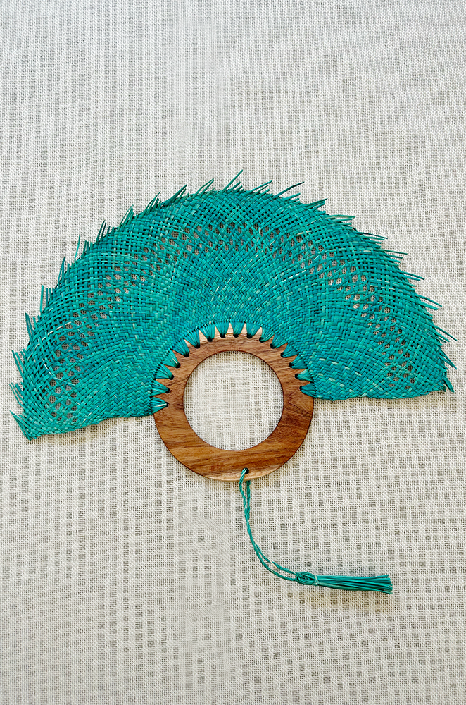 mexican woven palm fan in blue with a circular wooden handle