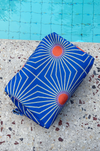 colorful toiletry bag with a mid century style print in blue, white and orange.