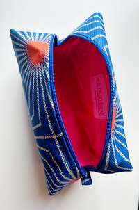 top view of a makeup bag open. The lining is bright pink.