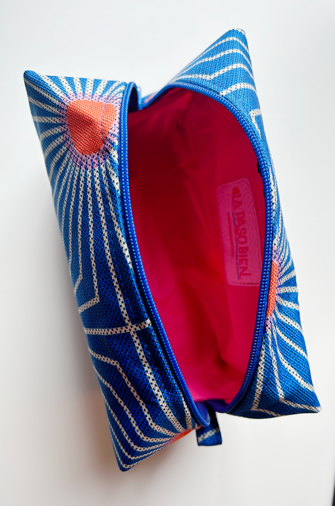 top view of a makeup bag open. The lining is bright pink.